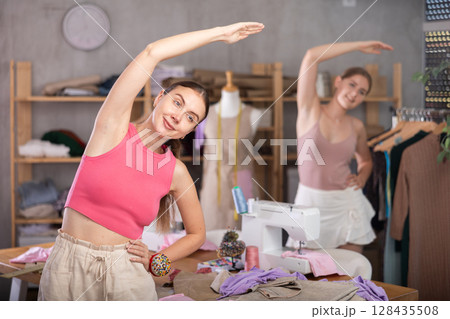 Dressmakers warming up together during a break 128435508