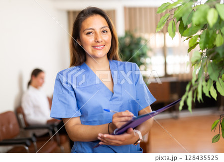 Portrait of friendly female doctor wearing uniform Portrait of friendly female doctor wearing uniform 128435525