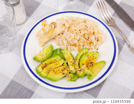 Healthy dinner of basmati rice with chicken breast and avocado 128435580