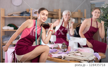 Three women tailors are moving and doing warm-up Three women tailors are moving and doing warm-up 128435718