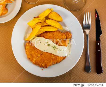 Chicken escalope with roquefort sauce, served with crispy french fries 128435781