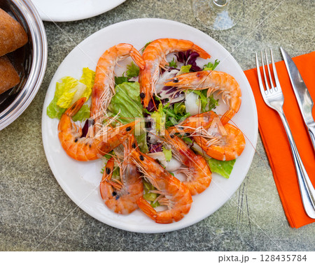 Shrimp served with vegetable salad on platter 128435784