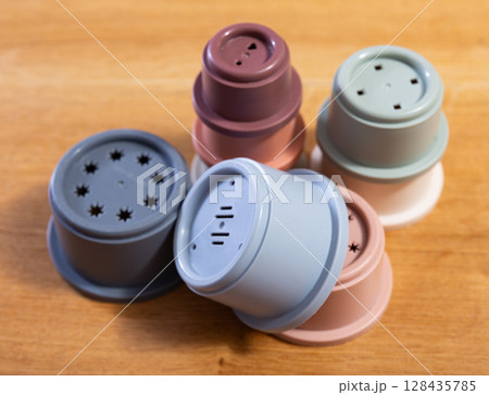 Plastic cups of disassembled pyramid scattered on wooden table 128435785