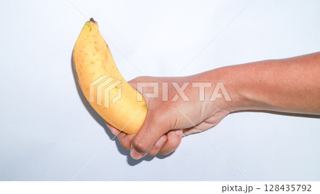 Asian woman holding banana in hand. Tropical fruit, organic nutrition, healthy lifestyle, funny banana. 128435792