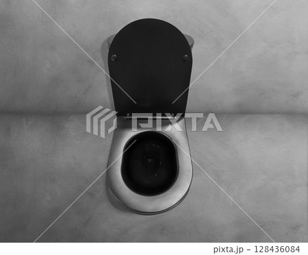 Top view of black toilet bowl with open lid on cement floor. Top view of black toilet bowl with open lid on cement floor. 128436084
