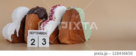 23 September calendar date National Baker day Heart shaped dark chocolate flavor croissant on beige background with copy space. Puff pastry new trendy sweet dessert bakery. Creamy dough 23 September calendar date National Baker day Heart shaped dark chocolate flavor croissant on beige background with copy space. Puff pastry new trendy sweet dessert bakery. Creamy dough 128436650