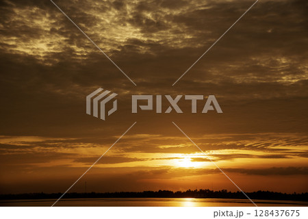 Tropical amazing dramatic golden sky on sunset over scenic river lake seascape ocean. Silhouette tranquil season wilderness serene landscape. Tranquil lake countryside sunrise seaside reflection Tropical amazing dramatic golden sky on sunset over scenic river lake seascape ocean. Silhouette tranquil season wilderness serene landscape. Tranquil lake countryside sunrise seaside reflection 128437675