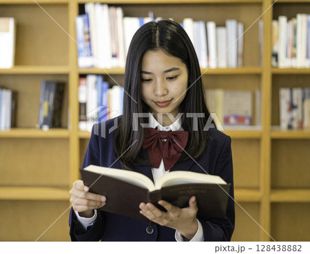 図書館で本を読む女子高校生、明るく清潔感ある学びと知的探求のイメージ 128438882