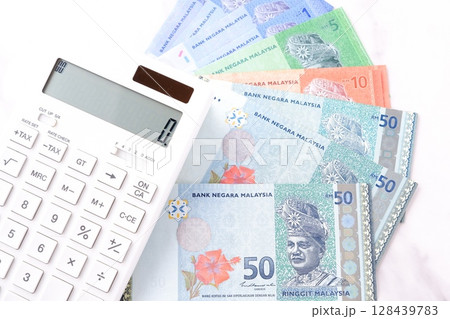 マレーシアの通貨、リンギット（MYR）の紙幣と、白い電卓	 128439783