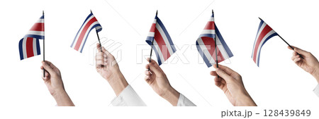 The Costa Rica flag in hand in different angles on a white background The Costa Rica flag in hand in different angles on a white background 128439849