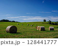 晴れ渡る夏空と牧草ロールが転がる景色 ( 北海道 上富良野町 ) 128441777