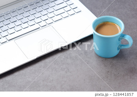 淹れたての美味しいコーヒーを飲みながら、ノートパソコンでデスクワークをしているイメージ 128441857