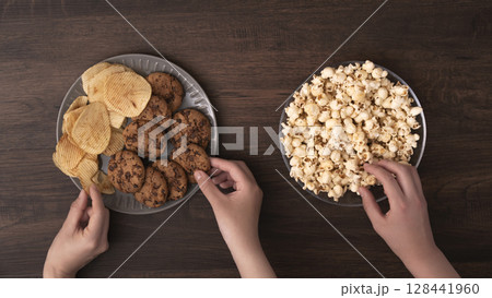 スナックやお菓子を食べる家族や仲間 128441960