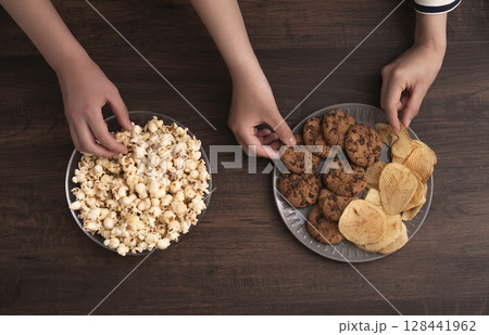 スナックやお菓子を食べる家族や仲間 スナックやお菓子を食べる家族や仲間 128441962