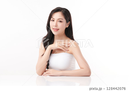A beautiful young Asian woman with clean, fresh skin against a white background. Skincare, facial treatment, cosmetology, beauty, and spa. An elegant portrait of an Asian woman. 128442076