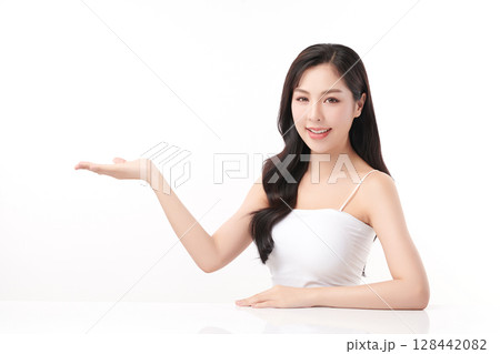 A beautiful young Asian woman with clean, fresh skin against a white background. Skincare, facial treatment, cosmetology, beauty, and spa. An elegant portrait of an Asian woman. 128442082