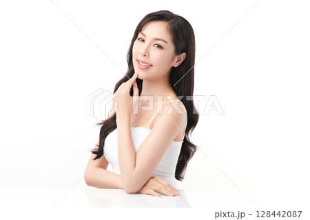A beautiful young Asian woman with clean, fresh skin against a white background. Skincare, facial treatment, cosmetology, beauty, and spa. An elegant portrait of an Asian woman. 128442087