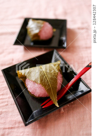 黒い皿にのった桜餅 128442307