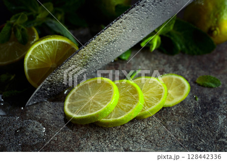 Knife, slices of lime and sprigs of fresh mint. 128442336