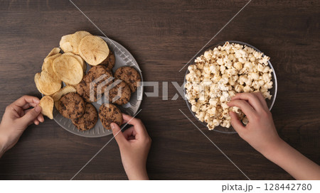 スナックやお菓子を食べる家族や仲間 128442780