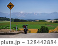 丘の上のツーリングバイクと十勝岳連峰を望む景色 ( 北海道 美瑛町 ) 128442884