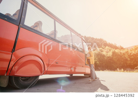Bus, Mountains, Travel: People getting off a red bus in a scenic mountainous area for a travel adventure. Bus, Mountains, Travel: People getting off a red bus in a scenic mountainous area for a travel adventure. 128445392