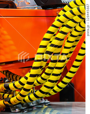 Colorful coiled hoses are seen in an industrial setting during daytime work hours in a busy factory 128445887