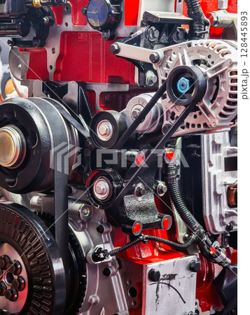 Engine components featuring belts and pulleys showcase intricate mechanics in automotive design 128445893