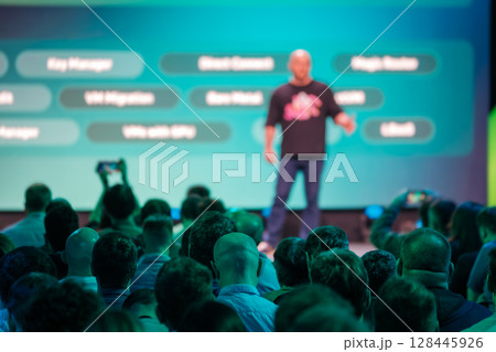 Speaker presenting technology concepts to audience at corporate conference 128445926