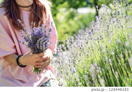 Woman holding lavender bouquet in blooming field Woman holding lavender bouquet in blooming field 128446183