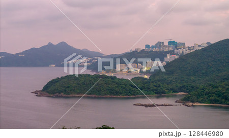 July 4 2025 Scenic Coastal View of Lush Hills and City Buildings at Dusk 128446980