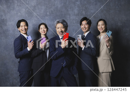 スマホを持つビジネスマンたち 128447245