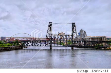 Double-deck vertical-lift Steel Bridge spans the Willamette River in Portland, Oregon, United States, and carries road, rail, pedestrian, and light rail traffic Double-deck vertical-lift Steel Bridge spans the Willamette River in Portland, Oregon, United States, and carries road, rail, pedestrian, and light rail traffic 128447311