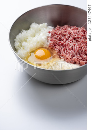 白背景に牛豚合挽き肉と玉ねぎ卵パン粉が入ったボウルのハンバーグ材料 128447467