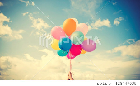 Colorful balloons fly with joy in the blue sky above a summer beach celebration 128447639