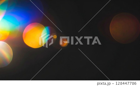 A glowing blue lens flare from a digital film projector shines through the dark night sky, creating a bright, artistic effect A glowing blue lens flare from a digital film projector shines through the dark night sky, creating a bright, artistic effect 128447786