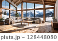 Modern mountain cabin living room with panoramic windows overlooking snowy alpine landscape 128448080