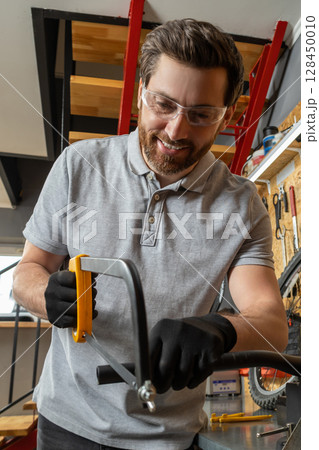 Bike mechanic in workwear using tools to repair bicycle Bike mechanic in workwear using tools to repair bicycle 128450010