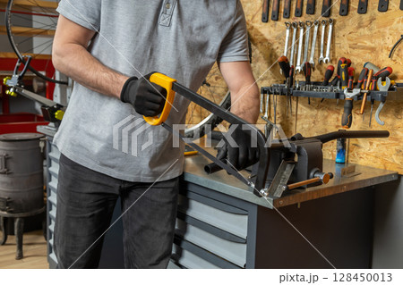 Bike mechanic in workwear using tools to repair bicycle 128450013