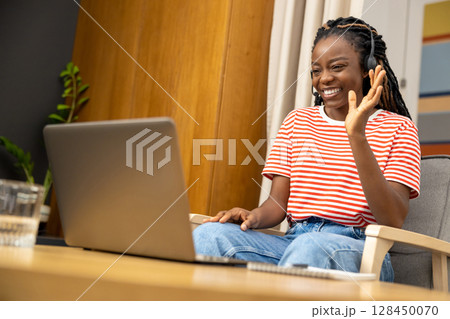 Young woman having a video call and looking excited 128450070