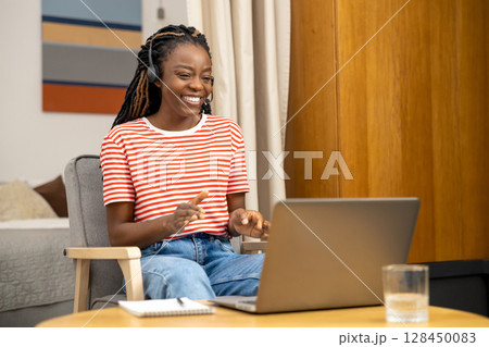 Contented young woman having a talk online and looking happy and excited Contented young woman having a talk online and looking happy and excited 128450083