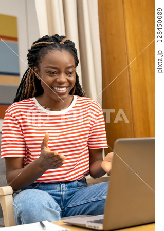 Contented young woman having a talk online and looking happy and excited Contented young woman having a talk online and looking happy and excited 128450089