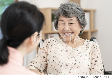 女性介護士と話をするシニア女性 女性介護士と話をするシニア女性 128450644
