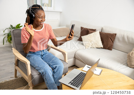 Smiling young woman having a video call and looking happy 128450738