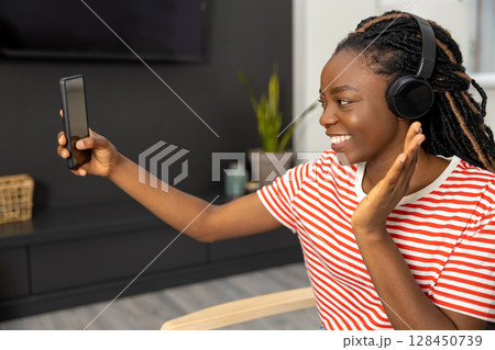 Smiling young woman having a video call and looking happy 128450739