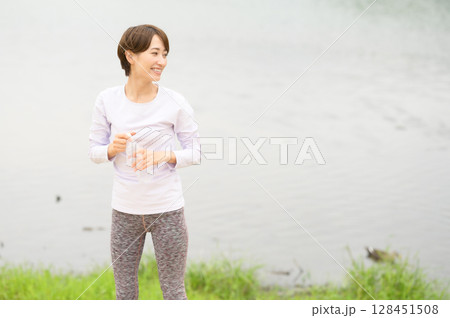 公園で水分補給する女性 公園で水分補給する女性 128451508