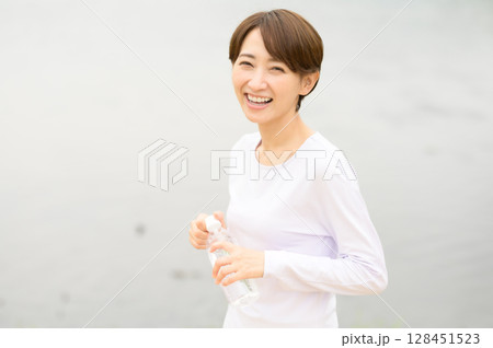 公園で水分補給する女性 公園で水分補給する女性 128451523