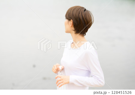 公園で水分補給する女性 公園で水分補給する女性 128451526