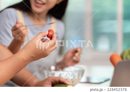 Healthy Cooking Together: Friends Preparing Fresh Ingredients in Modern Kitchen 128452378