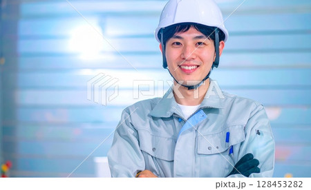 ヘルメットを着用して腕組みをする作業服の男性 128453282